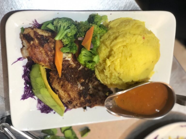 A plate showcasing a perfectly grilled fish fillet accompanied by creamy mashed potatoes, a delectable dish from Irman Restaurant and Cafe.