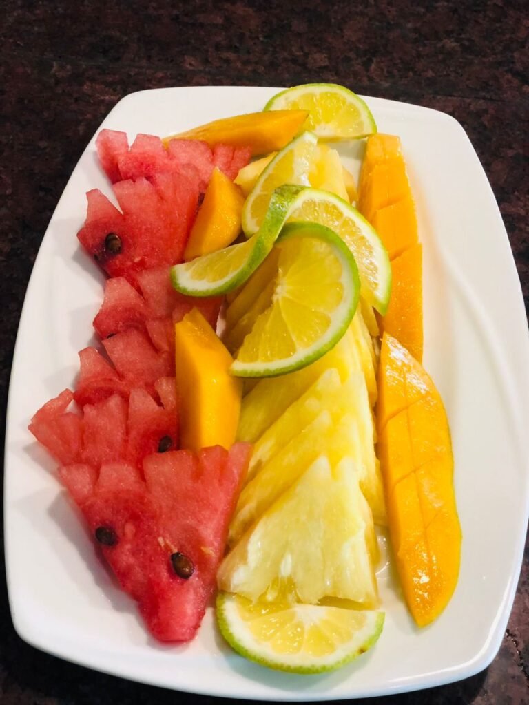 A colorful assortment of fresh fruits arranged on a plate, a refreshing option available at Irman Restaurant and Cafe.