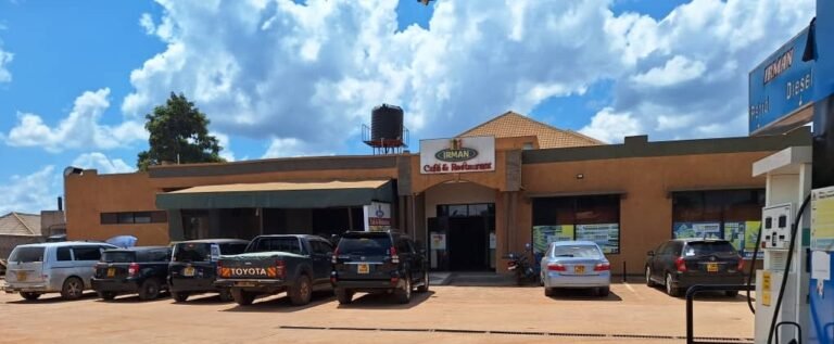 A photograph capturing the full front view of Irman Restaurant and Cafe under a bright, sunny sky.